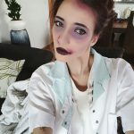 Девушка в белом халате с тёмной помадой, растушёванными тенями и собранными волосами