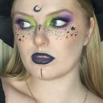 Макияж ведьмы на Хэллоуин с зелёными и фиолетовыми тенями, чёрными звёздами и месяцем на лбу